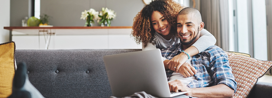Couple smiling at their laptop