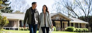 Couple smiling outside their home
