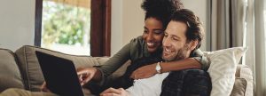 Couple smiling at their laptop