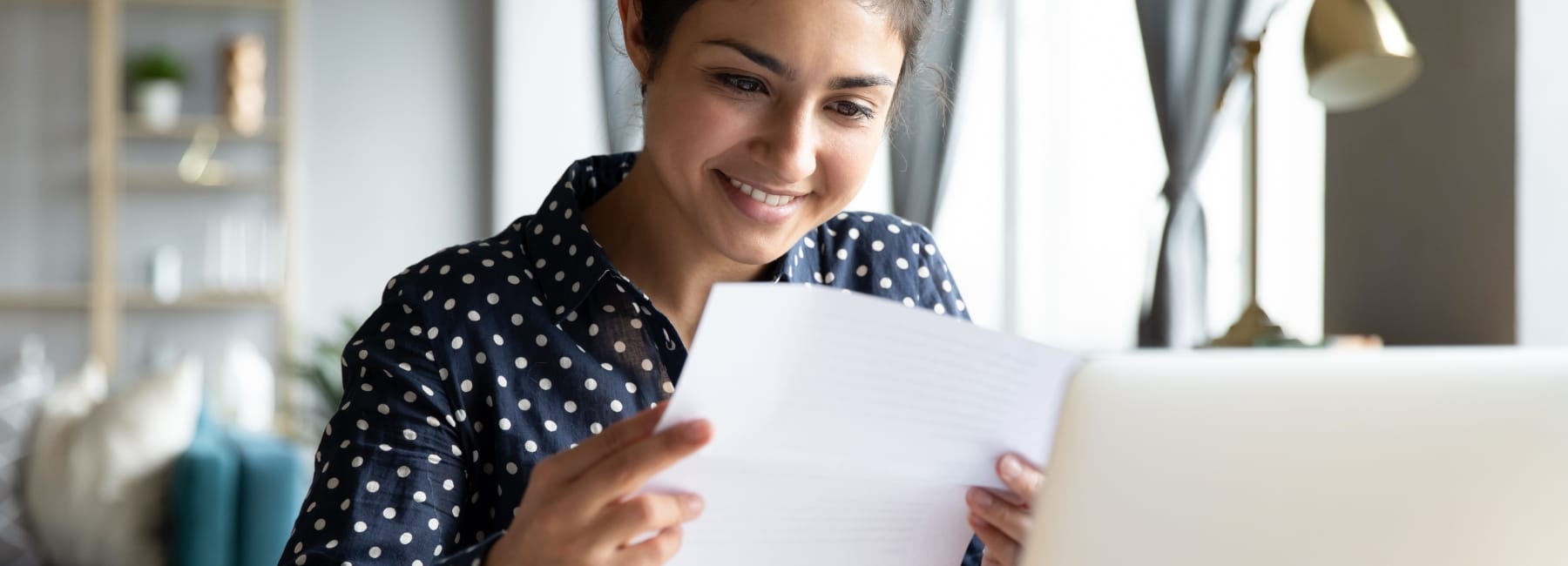 Woman smiling at a piece of paper