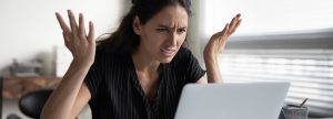 Frustrated woman looking at her laptop
