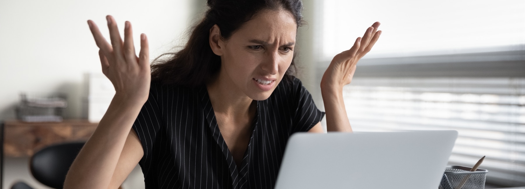 Frustrated woman looking at her laptop