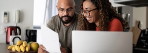 A couple smiling at their laptop