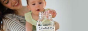 Baby putting change into a college fund jar