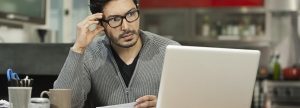 Man looking at his laptop frustrated