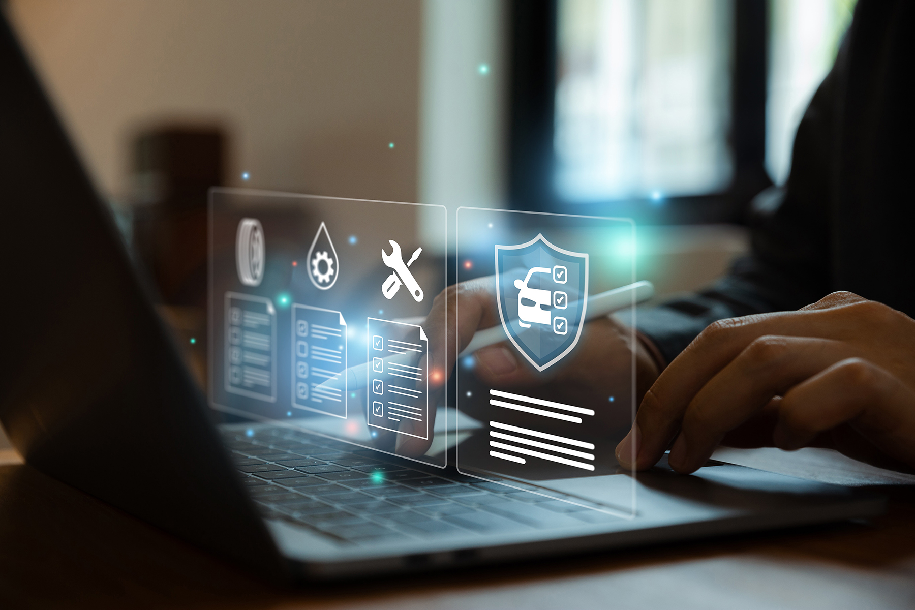 A person is using a laptop with holographic icons displayed above the keyboard, representing various aspects of vehicle maintenance and security, such as a wrench, a shield with a car, and checklists.