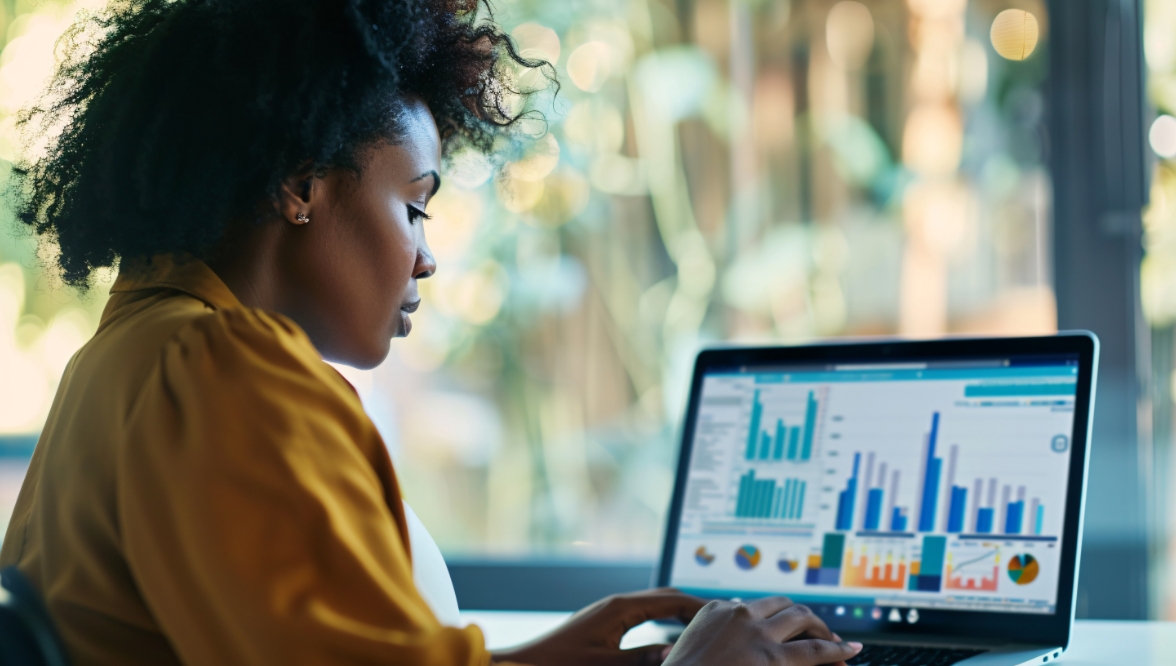 A person looking at a laptop screen displaying various financial graphs and charts.