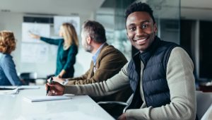 Young college graduate starting a professional career, sitting in a conference room.
