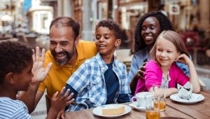 Members of a happy family enjoy dessert and each other’s company at an outdoor café.